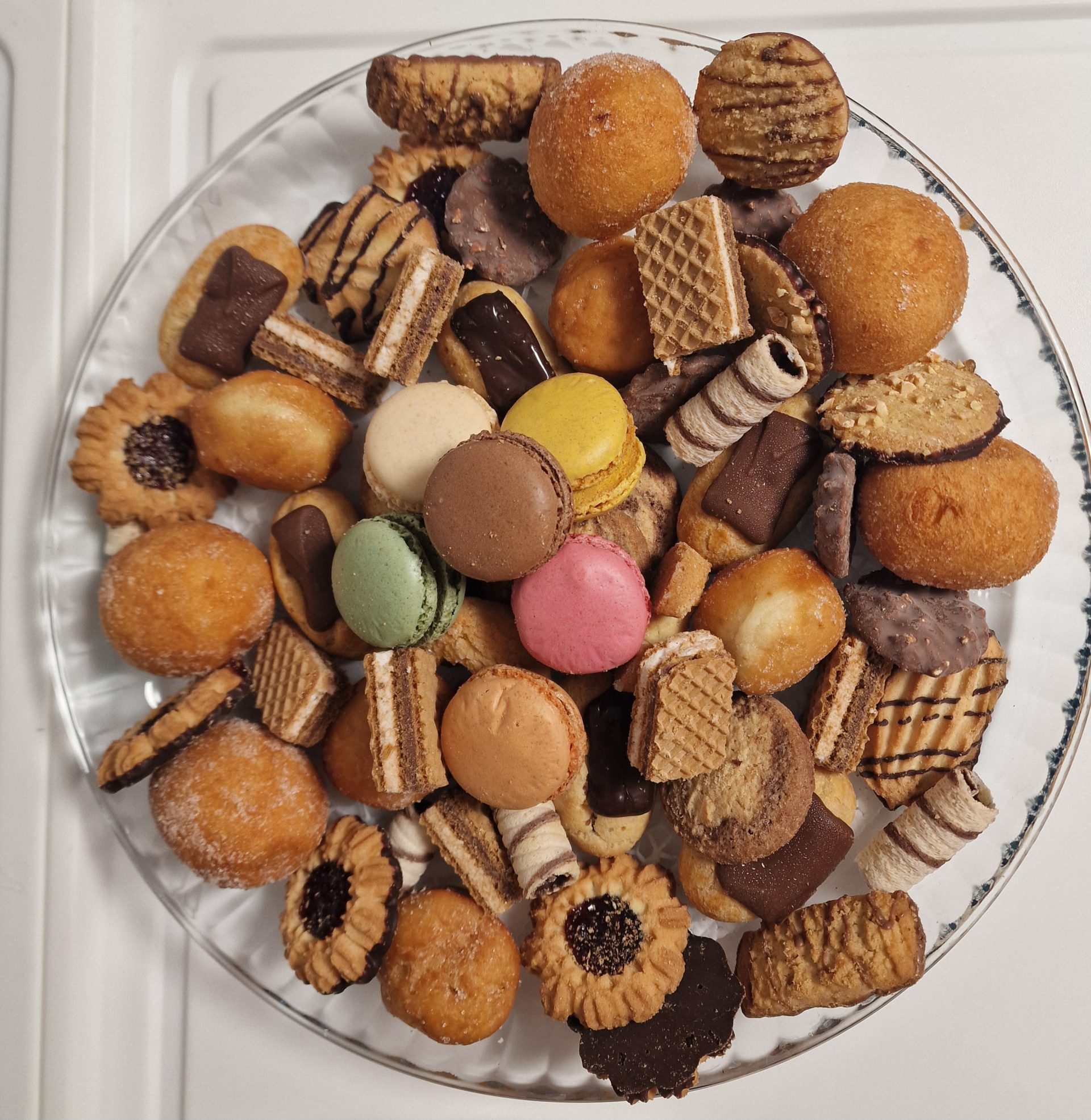 Teller mit Macarons und verschiedenen kleinen Keksen/Gebäckstücken.